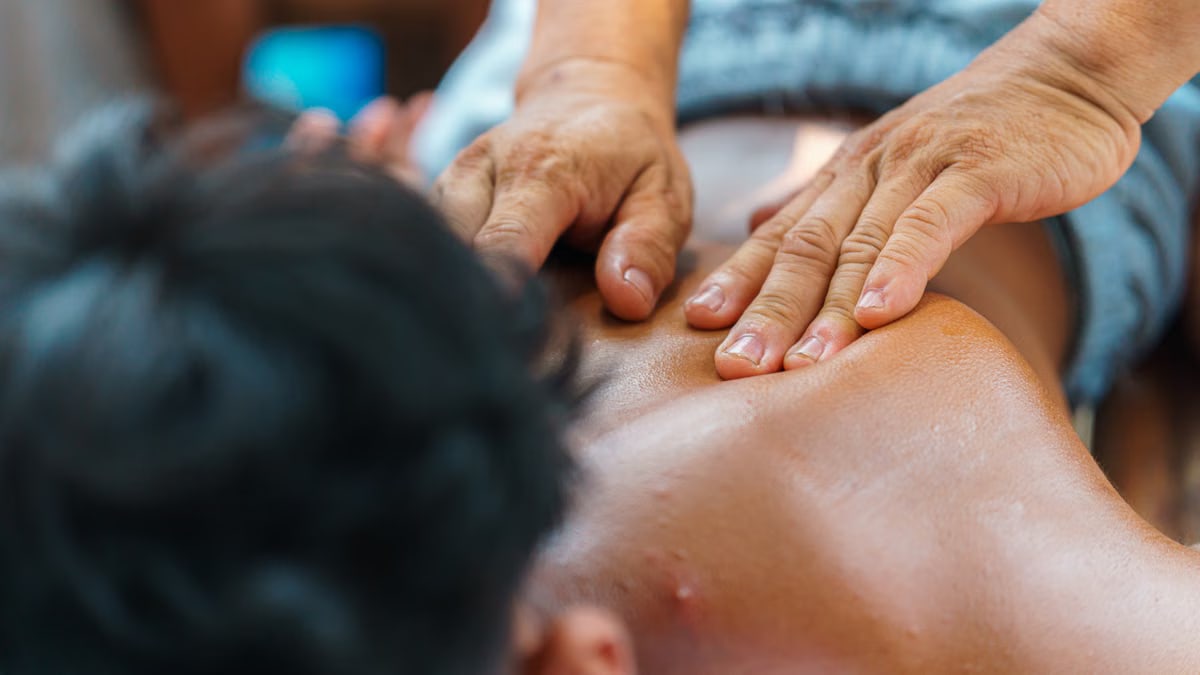 Close-up of hands performing a therapeutic back massage, promoting relaxation and wellness.
